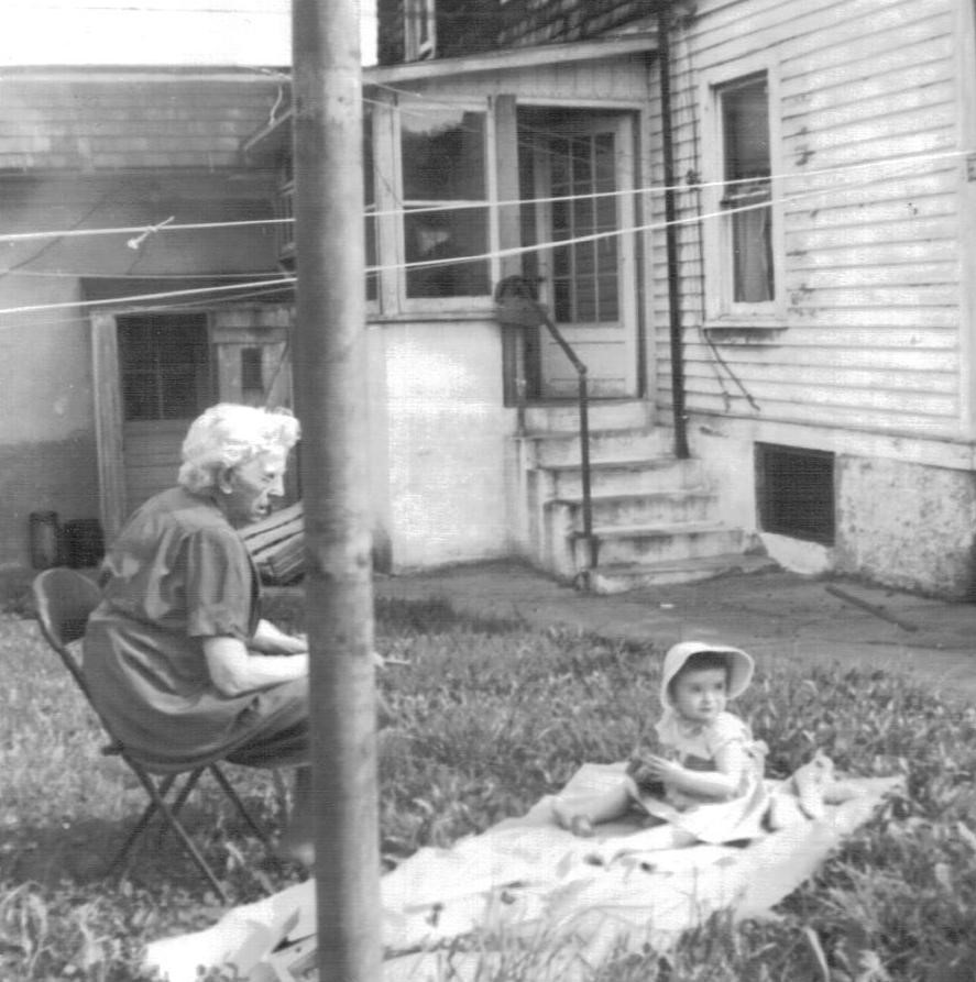 Ida in a chair, Jill on a blanket on the ground